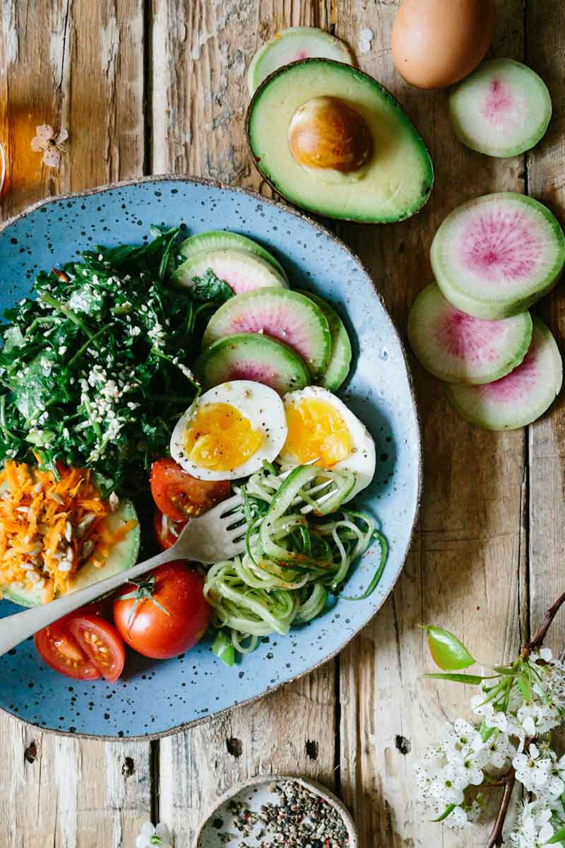 Teller mit unterschiedlichem Gemüse, Eier und Avocado